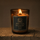 Spirituum candle in a glass container with a label on a stone surface