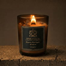 Spirituum candle in a glass container with a label on a stone surface